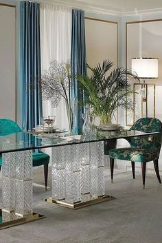 an elegant dining room with blue chairs and a glass table in front of the window