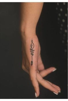 a woman's hand with a small tattoo on it