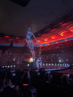 a person standing on top of a stage in front of an audience at a concert