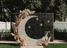 a large metal crescent with stars and moon on it sitting in the middle of a yard