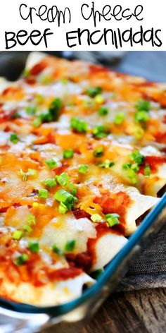 a cheesy beef enchiladas in a glass dish with green onions and cheese