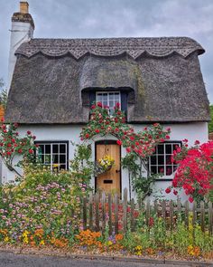 a white house with flowers growing around it