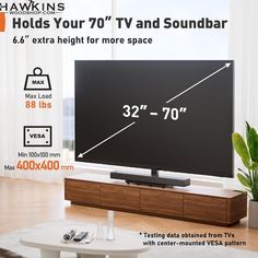 a flat screen tv sitting on top of a wooden stand