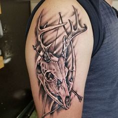 a man with a deer head tattoo on his arm