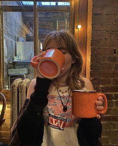 a woman drinking out of a coffee cup