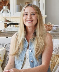 a woman sitting on top of a couch smiling