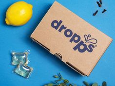 an open box with the word drop on it next to some lemons and seeds