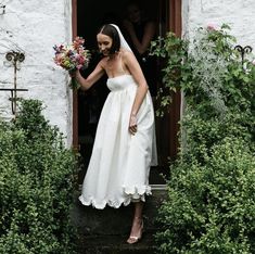 a woman in a white wedding dress standing on steps