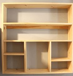 an empty wooden shelf against a wall