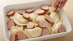 a white dish filled with sliced up sausages