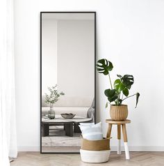 a mirror sitting on top of a wooden table next to a plant in a pot