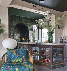 a living room filled with furniture next to a kitchen counter top and potted plants