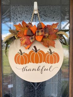 a door hanger decorated with fall leaves and pumpkins