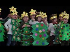 a group of children in christmas costumes standing next to each other with trees on their heads