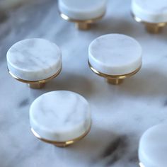 white marble knobs with gold accents on a marble surface