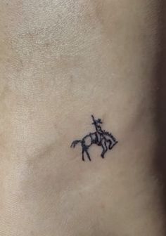 a small horse tattoo on the ankle