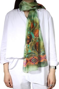 This silk scarf is designed and handmade in Armenia, by sisters Anna and Azatuhi Stepanyan. The scarf is hand painted in the technique of cold batik. The motifs include pomegranates, considered a symbol of fertility and good fortune in Armenia, as well as a guard against the Evil Eye. The multicolored scarf is framed with traditional Armenian motifs. Green Hand Dyed Bohemian Scarf, Bohemian Silk Scarf With Batik Print, Green Bohemian Silk Scarf As Gift, Green Bohemian Silk Scarf For Gift, Green Silk Bohemian Scarves, Bohemian Green Silk Scarf As Gift, Bohemian Green Silk Scarves, Bohemian Silk Scarf As A Gift, Bohemian Silk Scarves As Gifts