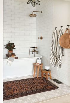 a bathroom with a rug, bathtub and two towels hanging on the wall next to it