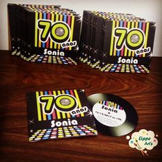 three cd's sitting on top of a wooden table next to an album cover