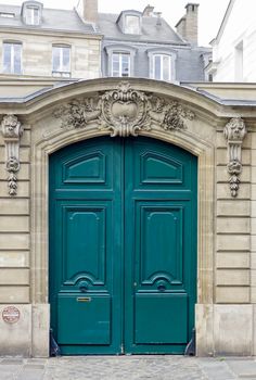 two green doors in front of an old building