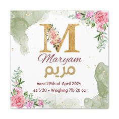 a card with the letter m in gold and pink flowers on it, next to an elephant