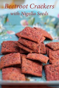 a plate full of beetroot crackers with nigglela seeds