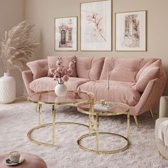 a living room with pink couches and coffee table in the middle, surrounded by pictures on the wall