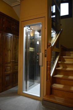 an empty room with wooden stairs and glass doors