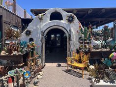 the entrance to a shop with many different types of plants and decorations on display in front of it