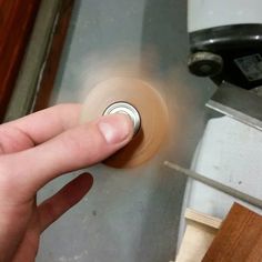 a person is pressing buttons on an appliance with their thumb and index finger