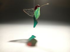 a glass hummingbird ornament hanging from a string