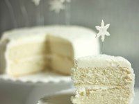 a slice of cake on a plate with snowflakes flying in the air behind it