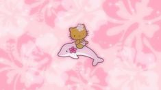 a hello kitty sitting on top of a dolphin with a flower in her hair and wearing a tiara