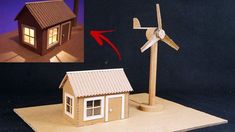 a house with a wind turbine next to it on a piece of paper that has been cut out