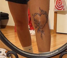 a woman's legs with flowers on them in front of a mirror