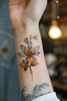 a woman's arm with a flower tattoo on it