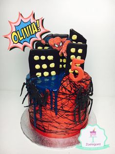 a spiderman themed birthday cake with sprinkles and decorations on the top