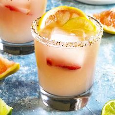 two glasses filled with lemonade and garnish next to sliced oranges