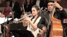 a man and woman playing musical instruments in front of an audience