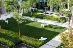 an aerial view of a courtyard with lawns, trees and sculptures in the center