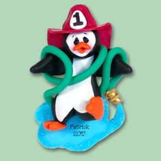 a figurine of a penguin wearing a fireman's hat and holding a hose