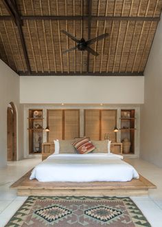 a large bed sitting under a wooden ceiling