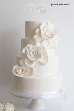 a white wedding cake with flowers on top