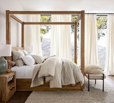 a bed with white linens and pillows in a bedroom next to a large window