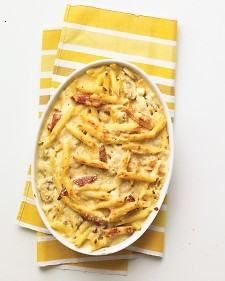 a white plate topped with macaroni and cheese on top of a yellow striped napkin