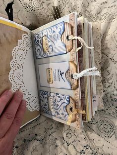 someone is holding an open book in their hand and it has lace on the pages