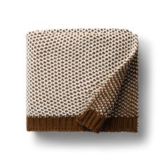 a brown and white blanket folded on top of each other