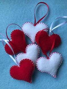 three red and white heart ornaments on a blue background