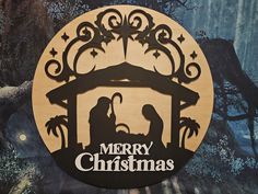 a merry christmas sign with a nativity scene in the center and stars above it