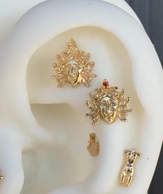 three pairs of gold earring designs on top of each other